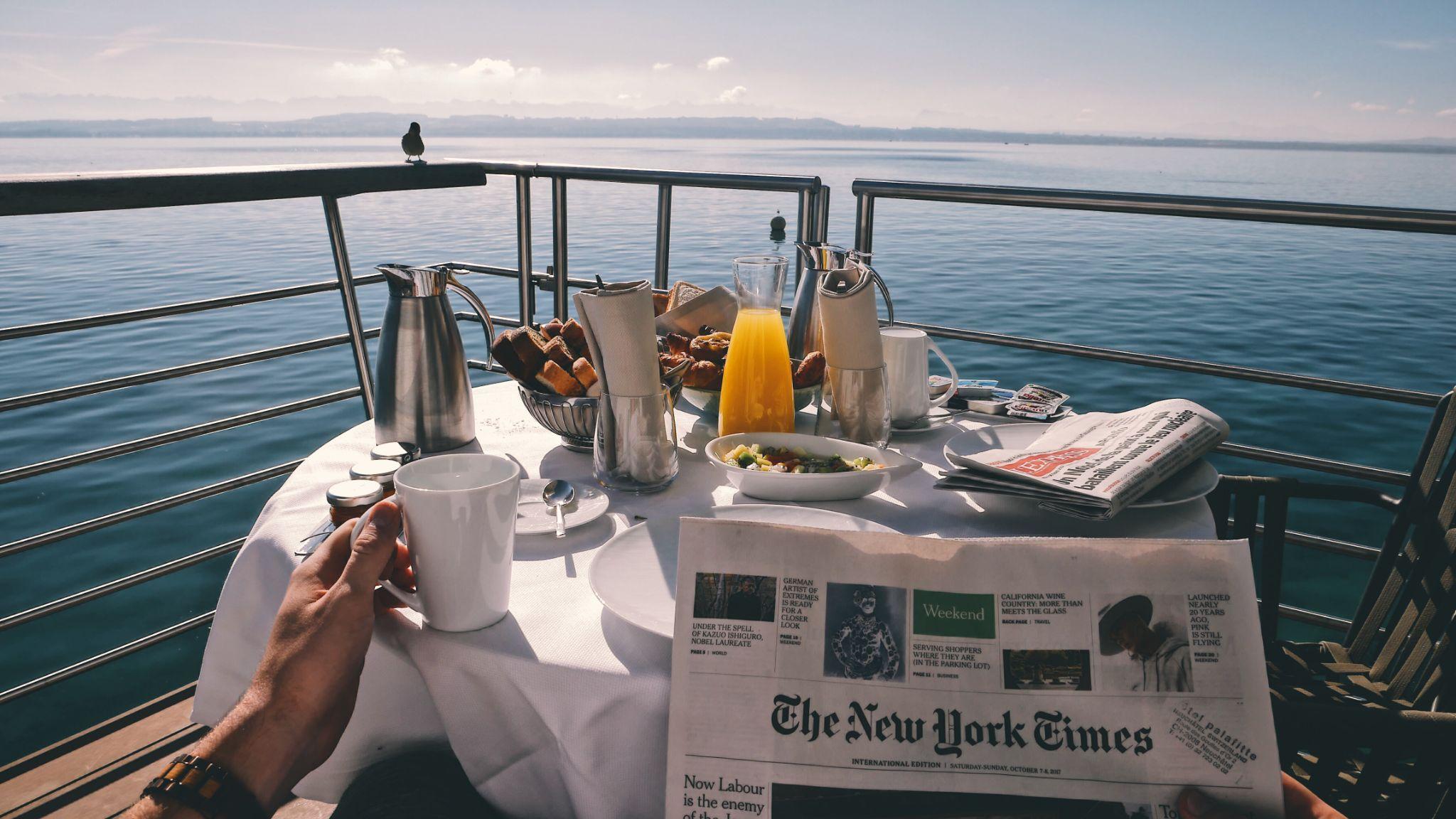 Man reading newspaper at breakfast on a cruise