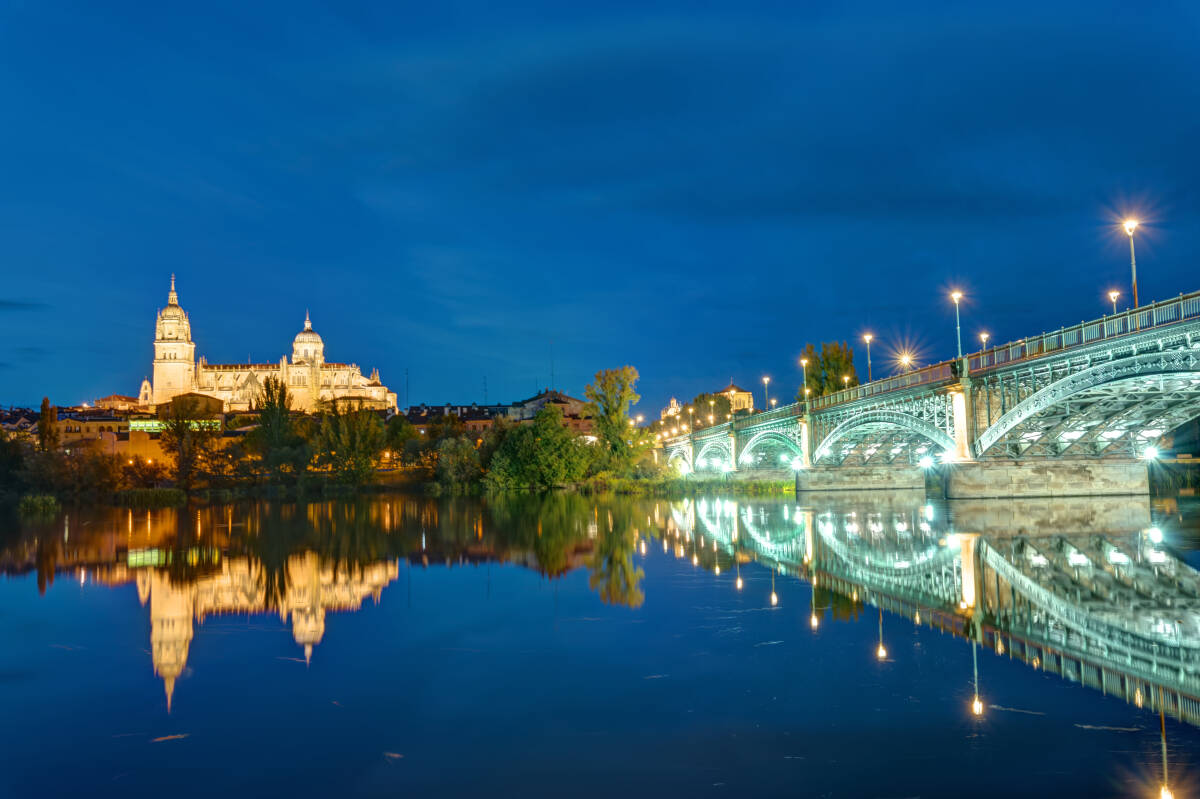 The Cathedral of Salamanca and the river Tormes with the Puente de Enruque Estevan at night.