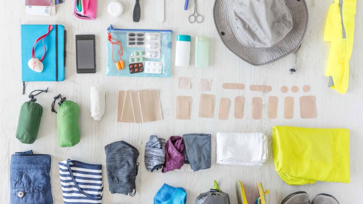 Trip travel gear and Travel essentials laid out on a table.