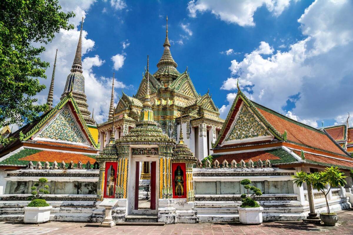 The majestic structures of Wat Pho, known for the Temple of the Reclining Buddha, stand vibrant in the heart of Bangkok