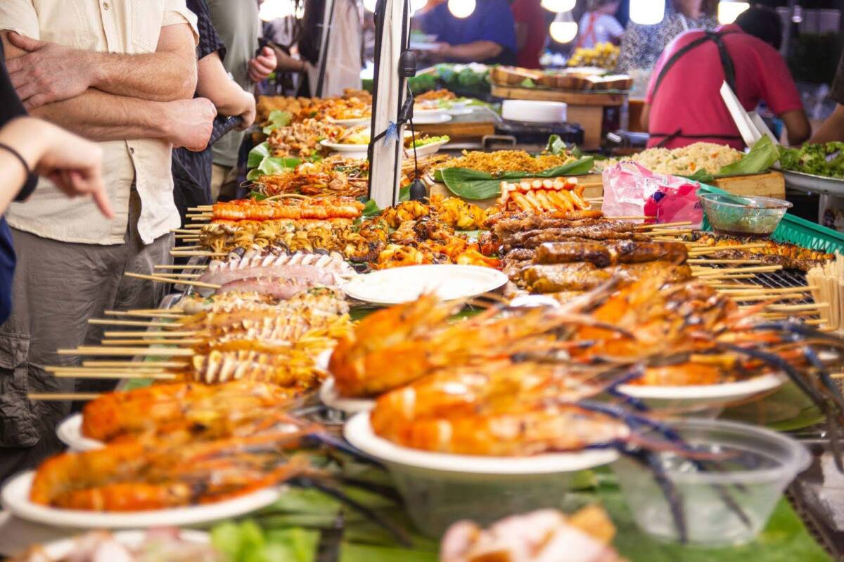 A vibrant selection of skewers and traditional Thai delicacies lined up at a Bangkok street food vendor.