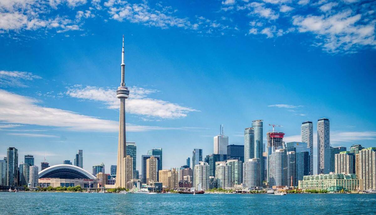 The skyline of Toronto, Canada, featuring the iconic CN Tower and surrounding skyscrapers on a clear day.