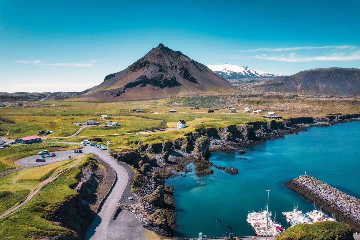 Beautiful Icelandic landscape featuring a quaint village, green hills, and a serene coastline.