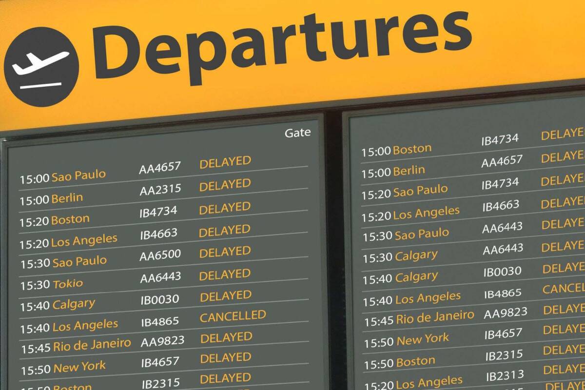 Airport departures board showing multiple delayed flights with destinations listed.