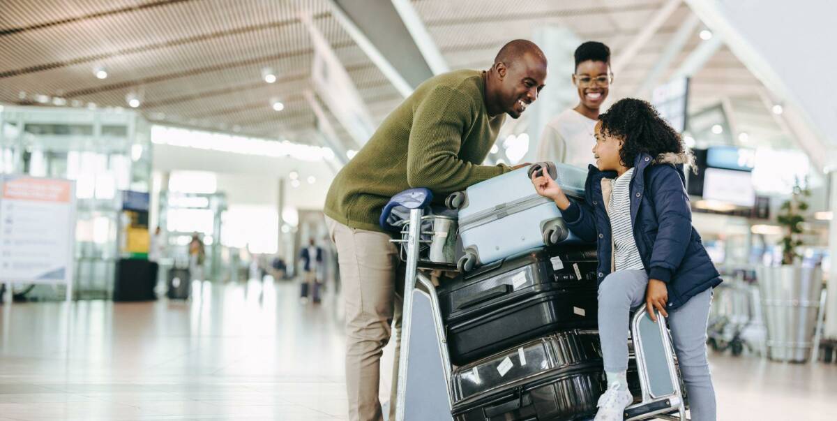 Happy family at airport taking multiple trips in a year.