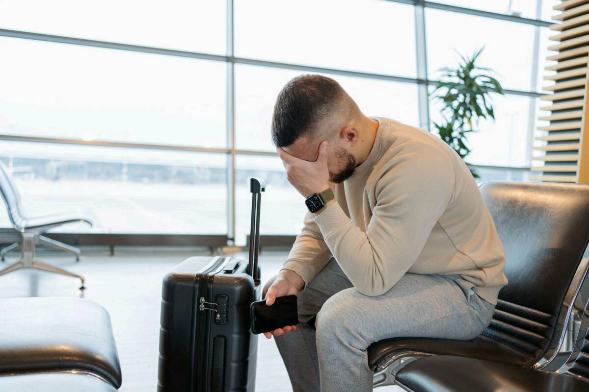 Sad man in airport due to hurricane cancellation