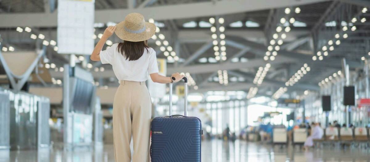 Woman traveling confidently at airport because she has travel insurance